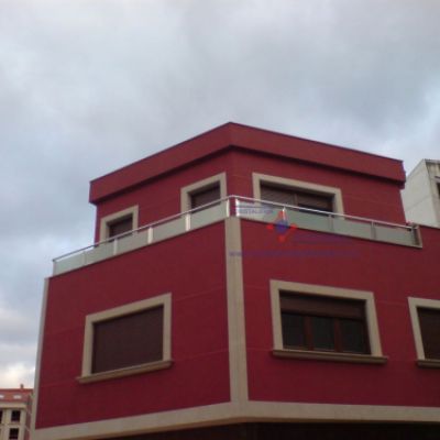 Edificio rojo con cerramiento de vidrio opaco